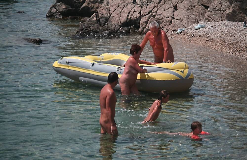 Lone Nudist in Yellow Boat photos - Naturists view nudity as a philosophy of life